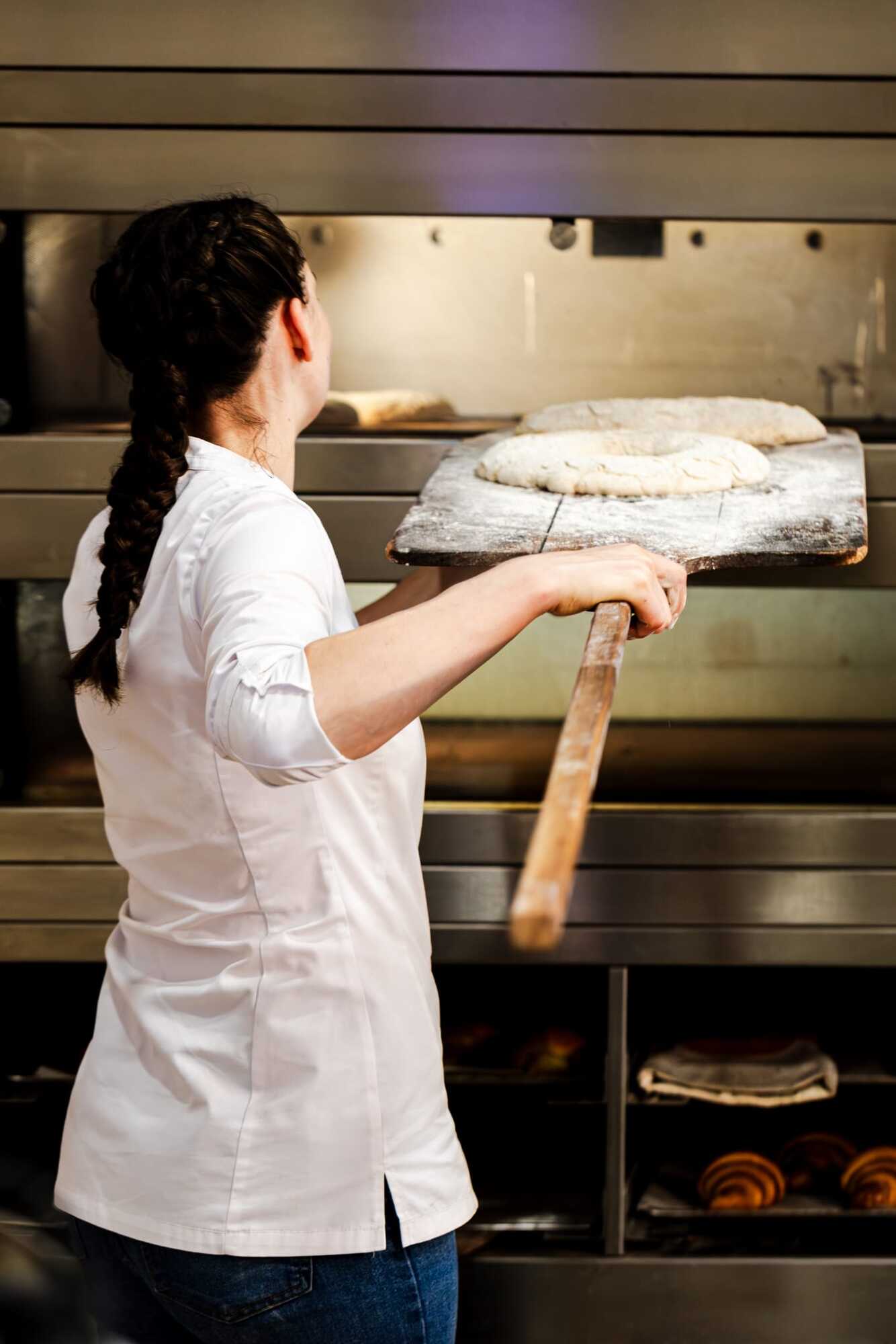 Sophie Schultz placing bread in an oven